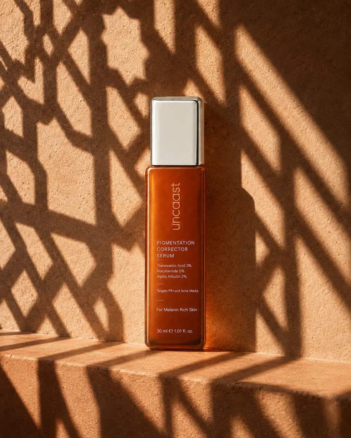 uncaast pigmentation corrector serum under the geometric shadow of a carved jaali screen